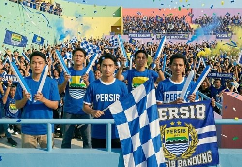 suporter persib bandung menggunakan balon tepuk untuk mendukung tim mereka